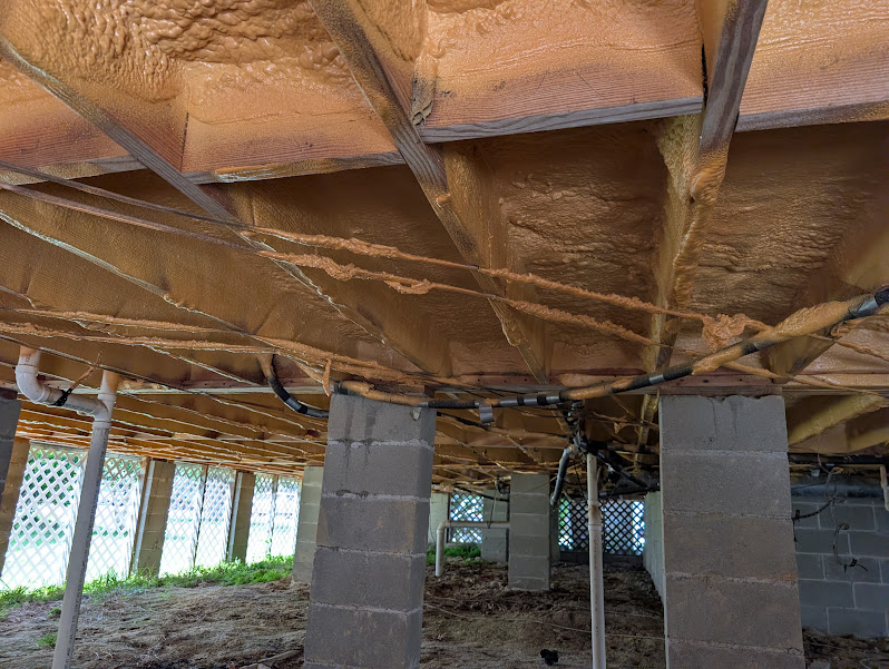 Spray foam insulation applied to the subfloor of a raised Charleston home